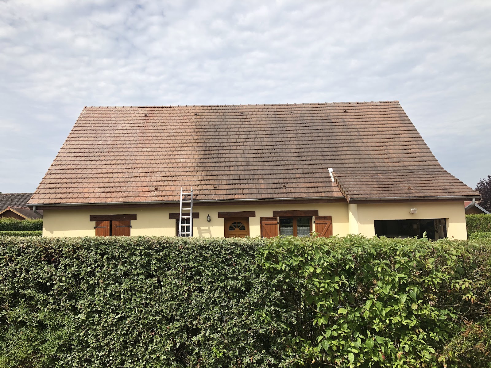 Nettoyage de toiture en cours sur une maison individuelle
